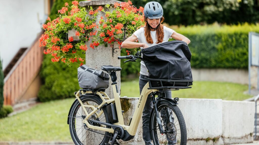 frau mit e-bike bei brunnen