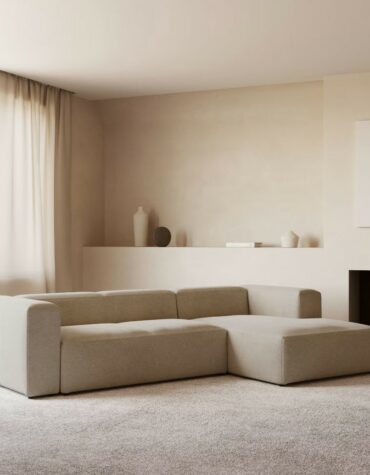 beiges Polster Sofa L-Form rechts in Wohnzimmer mit Teppichboden vor erloschenem Kamin