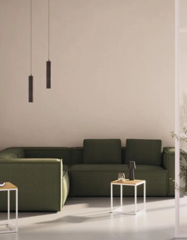 grünes Ecksofa in Wohnzimmer mit zwei Couchtischen